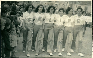'Grupo de garotas estudantes em desfile pelas ruas Palestina e Dr. Getúlio Portela, formando a palavra felipe com as letras de suas camisas, vê-se a antiga Casa Domingo 1960 a 1979