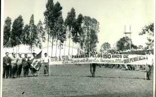 'Apresentação no Estádio Quinzinho Nery em comemoração ao sesquicentenário da independência do Brasil, vendo-se autoridades e uma faixa do Sindicato Rural de Campos Altos'1972 a 1972