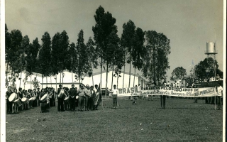 'Apresentação no Estádio Quinzinho Nery em comemoração ao sesquicentenário da independência do Brasil, vendo-se a fanfarra, estudantes, autoridades e uma faixa do Sindicato Rural de Campos Altos '1972a 1972