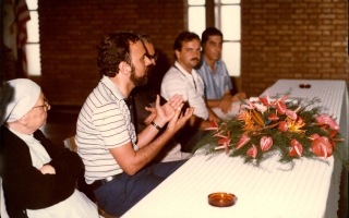 'Madre Emanuelle Favale, Prefeito Geraldo Barbosa Leão e outros à mesa durante reunião no Clube Social, um deles discursando Década de 80
