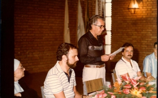'Prefeito Geraldo Barbosa Leão discursando durante reunião no Clube Social de Campos Altos, sendo assistido por Madre Emanuelle Favale Década de 80