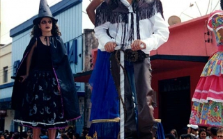 'Carro alegórico com meninas em fantasia de vaqueira e de bruxa, Débora e Laís, desfilando pela Praça Benedito Valadares ano 2000