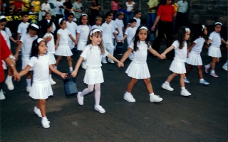 'Estudantes uniformizados em defile cívico pela rua, vendo-se Dehtiny Paula, Letícia, Marcela, entre outros  ano 2000