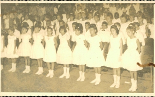 'Crianças não identificadas em pé vestidas de branco década de 50 e 60