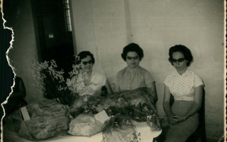'Homenagem para as professoras da Escola Estadual Deiró Borges, sentadas a mesa a esquerda da foto a Sra. Nilda Caporali Cordeiro e também Dona Alvorinda de Resende e pessoa não-identificada década de 50