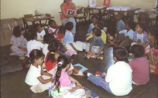 'Momento de contar histórias, realizado na Escola Municipal Amélia Franco, na foto na parte superior a professora Potinha e na parte inferior crianças não identificadas ano 2000