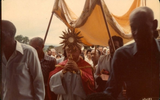 'Procissão com Padre Marques segurando o crucifixo com as mãos década de 80