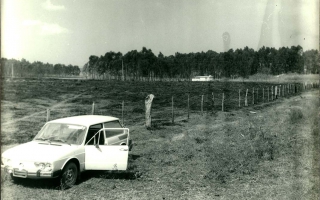 'Brasília estacionado em estrada de terra, ao fundo grande área desmatada e plantação de eucalipto década de 70