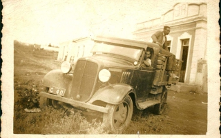 'Foto de um caminhão com placa de Ibiá com um rapaz dirigindo e outro na carroceria década de 70