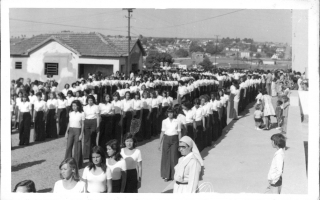 'Estudantes em desfile cívico pela Rua Cornélia Alves Biclaho, vendo-se ao fundo o casario do bairro Camposaltinho 1960 a 1979