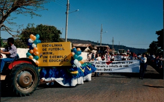 Desfile cívico em comemoração ao cinquentenário da emancipação política do município, vendo-se, em primeiro plano, um carro alegórico alusivo à Escolinha de Futebol Mirim, e ao fundo, muitas pessoas em desfile. 1994