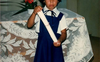 Formatura dos alunos da Escola Estadual Elizena Leão, na foto a aluna Renata, de pé uniformizada, segurando o diploma década de 80