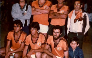 'Time de futebol de salão com uniforme laranjado década de 80