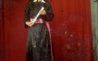 'Um garota com roupa de formanda e diploma na mão década de 80