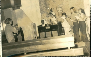 Irmã Dolores, Raimunda Lima, outras irmãs e coristas, um homem tocando violão e uma freira tocando piano década de 60