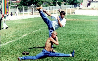 'Dois rapazes vestindo as cores branco e azul fazendo um exibição em movimentos de artes marciais. Tequinha e Júlio ano 2000