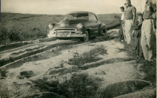 'Primeira estrada para Campos Altos em 1954, se vê um carro parado e várias pessoas ao lado década de 80