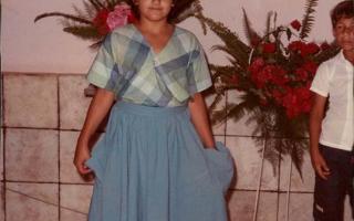 'Crisma na Igreja Matriz de Santa Terezinha, vestida com saia azul e blusa xadrez Lélia Rodrigues Bastos' década de 80